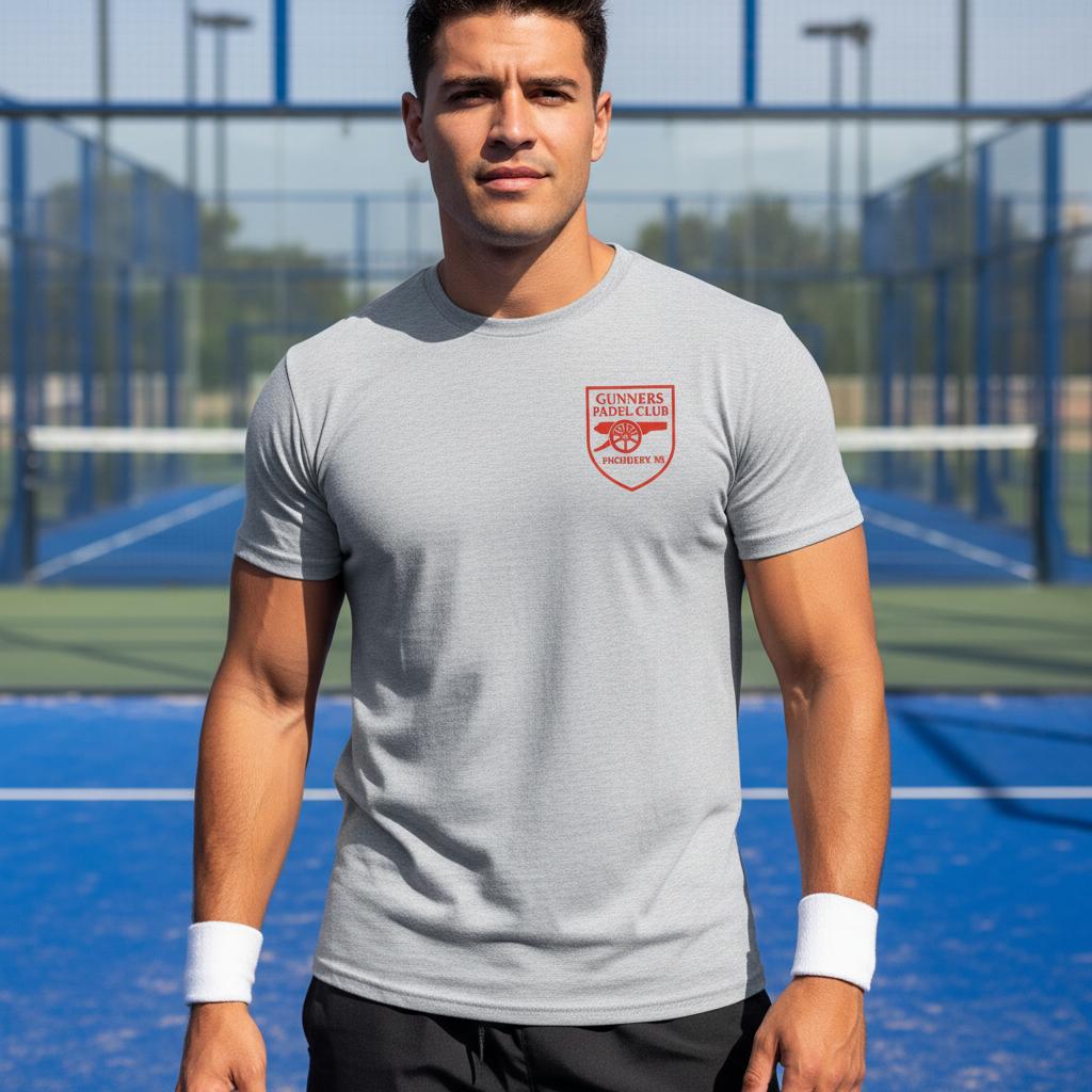Man wearing a gray Gunners Padel Club Arsenal  t-shirt with a logo on a tennis court